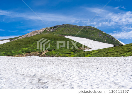 View of Mt. Gozenmine from the snowy fields of Mt. Hakusan Murododaira. Climbing Mt. Hakusan Gozenmine in early summer (Tonbi Rock Course) 130511397