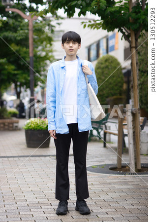 Portrait of a young man walking in the city 130512293