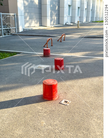 Red road barriers on the asphalt road near the building Red road barriers on the asphalt road near the building 130512294