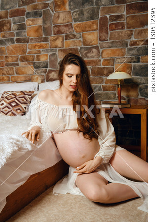 Expectant mother peacefully reflecting in cozy room with rustic brick wall Expectant mother peacefully reflecting in cozy room with rustic brick wall 130512395