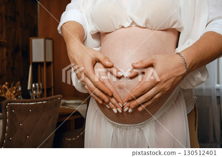 Expecting couple shares loving moment during joyful pregnancy celebration at home 130512401