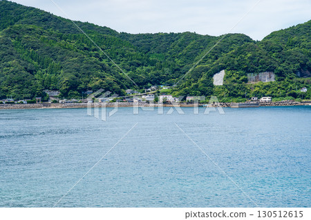 日南市牛島港的景色，周圍環繞著平靜的大海和山脈 130512615