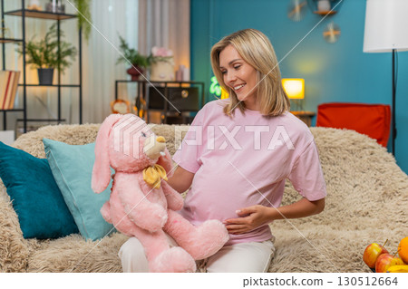 Pregnant woman hugging pink bunny toy showing love waiting baby arrival sweet tender moment of hope 130512664