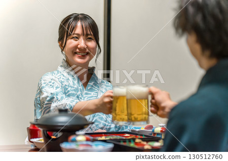 A couple in yukata sipping draft beer while enjoying a banquet A couple in yukata sipping draft beer while enjoying a banquet 130512760
