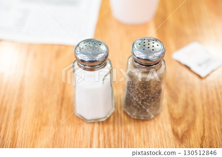 Glass bottles of salt and pepper on a restaurant table 130512846