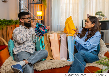 Indian family man woman unpacking shopping bags at home, happy with good purchases sales discounts 130512857