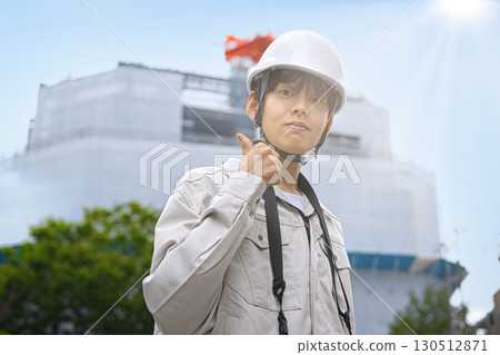 Young businessman in work clothes looking at a tablet at a construction site 130512871
