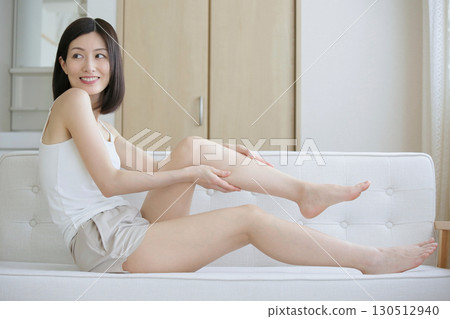 An adult woman doing foot care in the living room An adult woman doing foot care in the living room 130512940