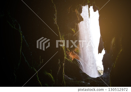 Waterfall cascading from rocky cliff inside dark mossy cave at monasterio de piedra, spain 130512972
