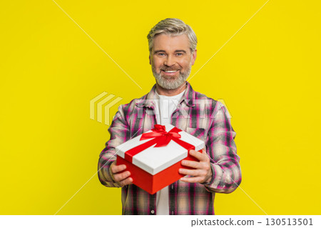Mature man gifting box with red ribbon, joyful smile gesture, celebration mood birthday surprise Mature man gifting box with red ribbon, joyful smile gesture, celebration mood birthday surprise 130513501