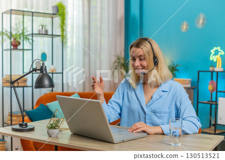 Businesswoman wearing headset support service operator helpline call center talking with client Businesswoman wearing headset support service operator helpline call center talking with client 130513521