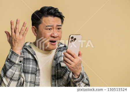 Upset sad man use smartphone play game loses loss fail unlucky news bad lottery results crisis 130513524