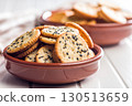 Crispy round salted crackers in bowl on white table. 130513659