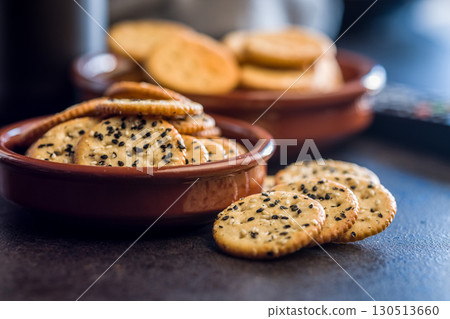 Crispy round salted crackers on black table. Crispy round salted crackers on black table. 130513660