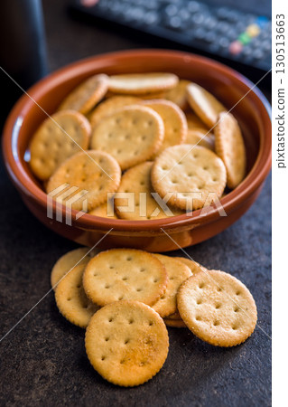 Crispy round salted crackers on black table. 130513663