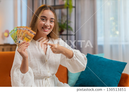 Successful rich happy smiling woman holding waving euro bills money fan winning online lottery game Successful rich happy smiling woman holding waving euro bills money fan winning online lottery game 130513851