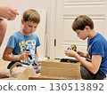 boys helping his father assemble a new piece of furniture with a screwdriver 130513892