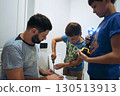 boys helping his father assemble a new piece of furniture with a screwdriver 130513913