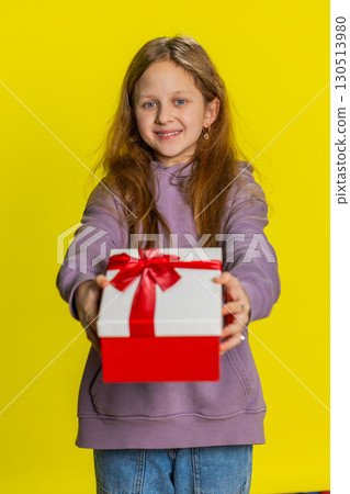 Lovely smiling preteen child girl kid presenting birthday gift box offer wrapped present celebrating 130513980