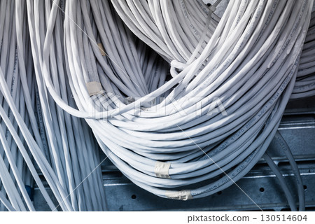 bunch of network cables in wave pattern leading across server ro 130514604