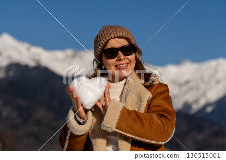 Snow Heart Mountains Woman: Winter joy, snowy landscape, woman holding heart-shaped snowball. Snow Heart Mountains Woman: Winter joy, snowy landscape, woman holding heart-shaped snowball. 130515001