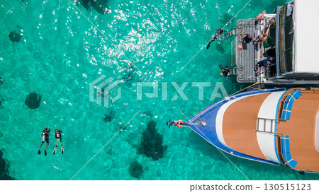 Aerial view of scuba divers swimming on water surface and climbing up on platform at Racha Island 130515123