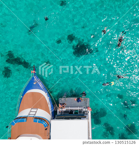 Aerial view of scuba divers swimming on water surface and climbing up on platform at Racha Island 130515126