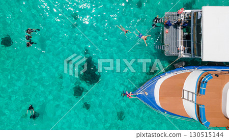 Aerial view of scuba divers swimming on water surface and climbing up on platform at Racha Island 130515144