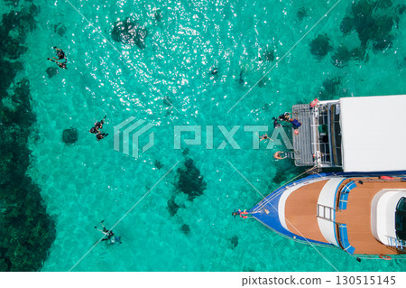 Aerial view of scuba divers swimming on water surface and climbing up on platform at Racha Island 130515145