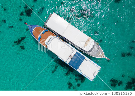 Aerial view of two boats anchoring over turquoise clear water at Racha Island in Phuket, Thailand. Aerial view of two boats anchoring over turquoise clear water at Racha Island in Phuket, Thailand. 130515180