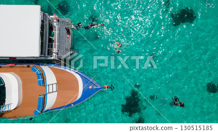 Aerial view of scuba divers swimming on water surface and climbing up on boat platform 130515185