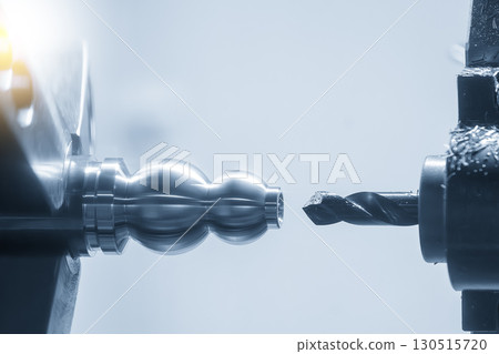 Close up scene the CNC lathe machine hole drilling process the metal shaft parts in the blue tone scene. 130515720