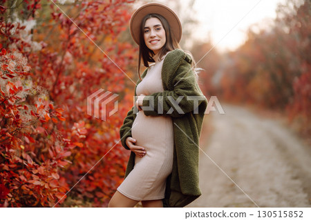Beautiful pregnant woman feeling lovely in the park. Motherhood. Maternity. Lifestyle concept. Beautiful pregnant woman feeling lovely in the park. Motherhood. Maternity. Lifestyle concept. 130515852