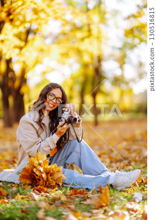 Beautiful woman taking pictures in the autumn forest. Rest, relaxation, tourism, lifestyle concept. 130516815