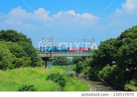 A freight train travels along the Yanase River in the summer, surrounded by dazzling greenery and summer skies. 130517070
