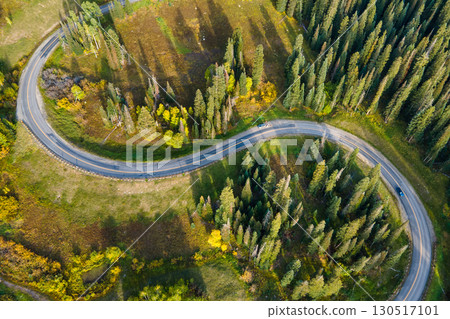 Aerial drone footage of S curve road winding through green pine and aspen forest Aerial drone footage of S curve road winding through green pine and aspen forest 130517101