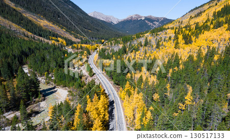 Aerial view of rural road winding through the yellow aspen forest during fall in Colorado, USA Aerial view of rural road winding through the yellow aspen forest during fall in Colorado, USA 130517133