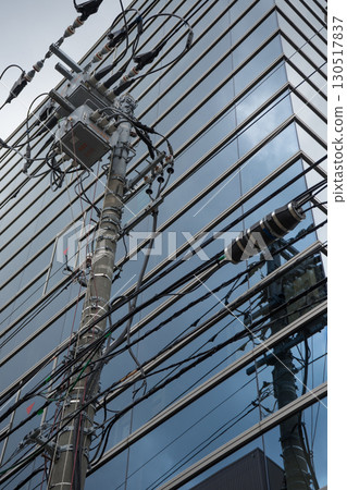 A jumble of utility poles and buildings 130517837
