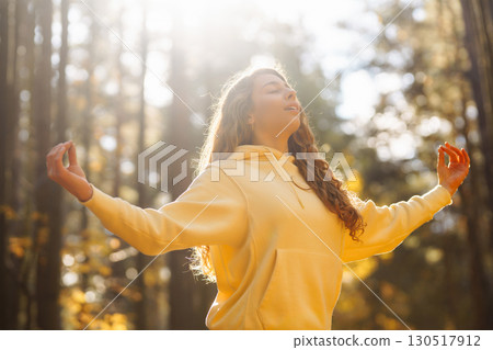 Beautiful woman practices yoga in the autumn forest. Lifestyle and meditation concept. Beautiful woman practices yoga in the autumn forest. Lifestyle and meditation concept. 130517912