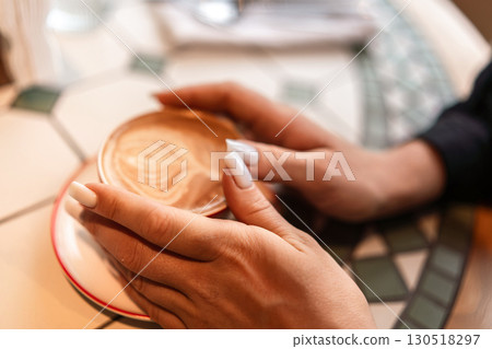 Coffee hands nails holding cappuccino art at cafe table indoors enjoying break. 130518297