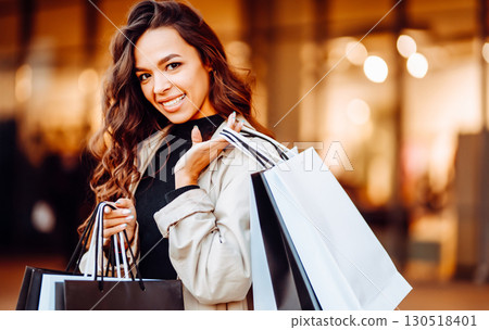 Young woman with shopping bags near mall. Spring Style. Consumerism, purchases, shopping, lifestyle 130518401