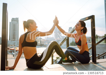 Two Young woman in sports outfit doing exercises outdoors in the morning. Sport, sports training. Two Young woman in sports outfit doing exercises outdoors in the morning. Sport, sports training. 130518713