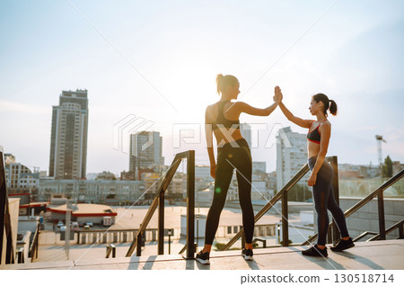 Two Young woman in sports outfit doing exercises outdoors in the morning. Sport, sports training. Two Young woman in sports outfit doing exercises outdoors in the morning. Sport, sports training. 130518714