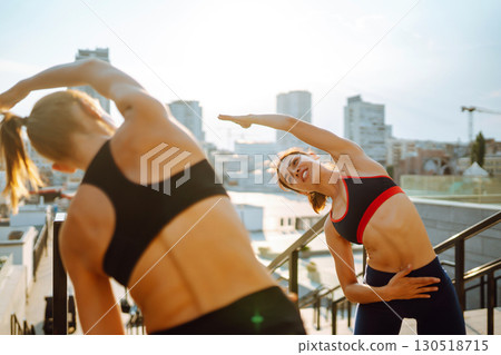 Two Young woman in sports outfit doing exercises outdoors in the morning. Sport, sports training. Two Young woman in sports outfit doing exercises outdoors in the morning. Sport, sports training. 130518715