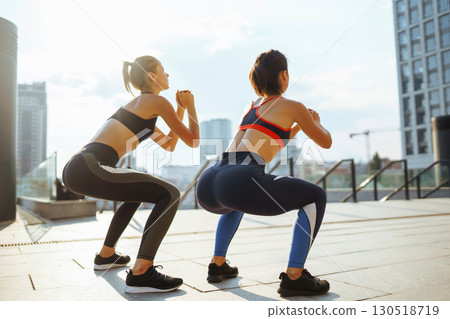 Two Young woman in sports outfit doing exercises outdoors in the morning. Sport, sports training. 130518719