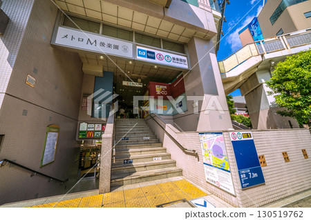Tokyo cityscape, Japan, September 7. View of Tokyo Metro Korakuen Station (entrance/exit) and a Marunouchi Line train (visible in the background on the right). Tokyo cityscape, Japan, September 7. View of Tokyo Metro Korakuen Station (entrance/exit) and a Marunouchi Line train (visible in the background on the right). 130519762