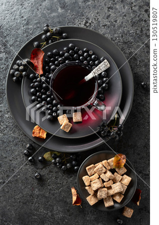 Black chokeberry juice, fresh berries, and pieces of brown sugar. Black chokeberry juice, fresh berries, and pieces of brown sugar. 130519807