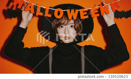 A man in a black knit sweater shows a surprised expression 130520623