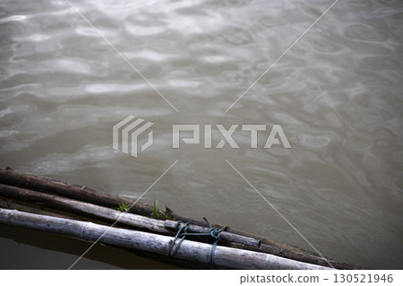 Bamboo Poles Tied As A Floating Barrier On Water  130521946