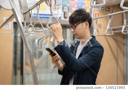 Man holding smartphone on train 130521993